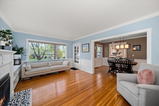 1123 W 25th Ave, Spokane, WA 99203 - living room with a fireplace with flush hearth, light wood-style flooring, ornamental molding, and a wainscoted wall