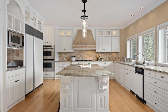 1714 E S Ridge Dr, Spokane, WA 99223 - kitchen with custom range hood, built in appliances, light wood-type flooring, a kitchen island, and decorative backsplash