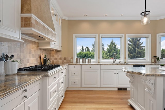 1714 E S Ridge Dr, Spokane, WA 99223 - kitchen with stainless steel gas cooktop, premium range hood, white cabinets, backsplash, and crown molding