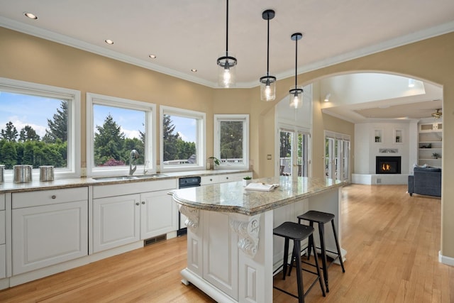 1714 E S Ridge Dr, Spokane, WA 99223 - kitchen with ornamental molding, light stone countertops, a kitchen island, light wood-style flooring, and decorative light fixtures