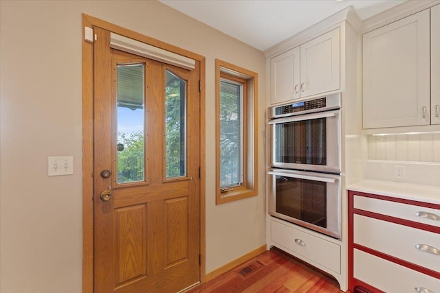 5430 S Quail Ridge Cir, Spokane, WA 99223 - kitchen with double oven, light wood finished floors, white cabinetry, and light countertops
