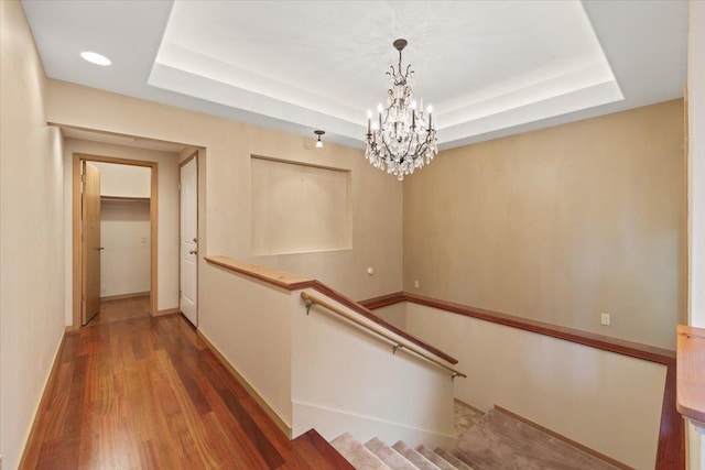 5430 S Quail Ridge Cir, Spokane, WA 99223 - hallway featuring a tray ceiling, a chandelier, and wood finished floors
