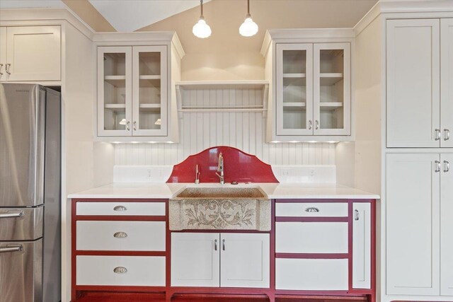 5430 S Quail Ridge Cir, Spokane, WA 99223 - kitchen with freestanding refrigerator, light countertops, hanging light fixtures, and glass insert cabinets