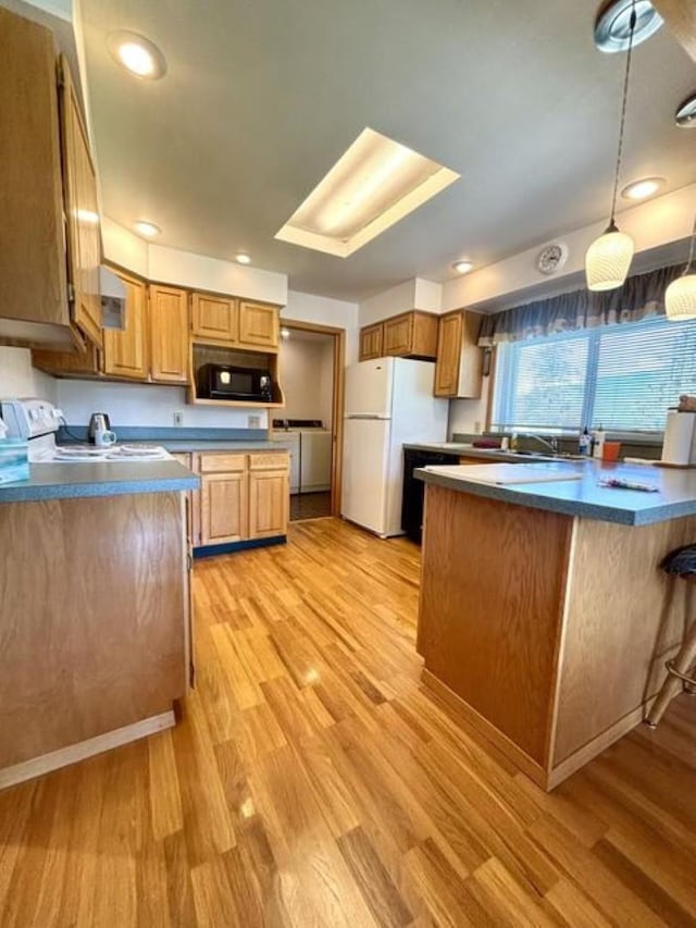 1425 N Chapin Rd, Evans, WA 99126 - kitchen with white appliances, light wood-style floors, dark countertops, and washing machine and clothes dryer