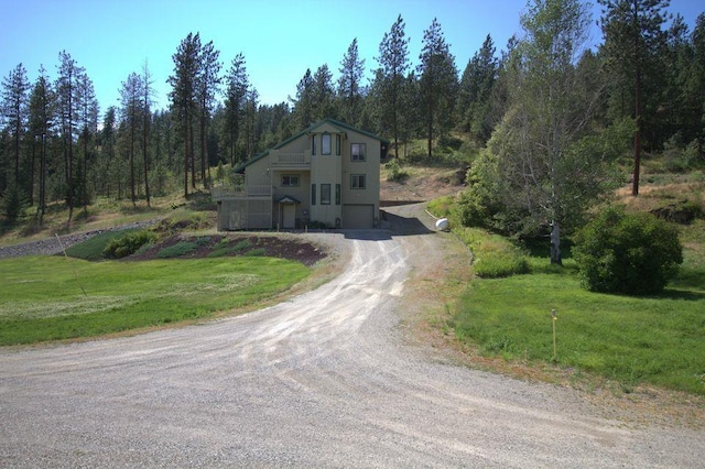 1425 N Chapin Rd, Evans, WA 99126 - view of front of house with dirt driveway, an attached garage, a front yard, and a wooded view