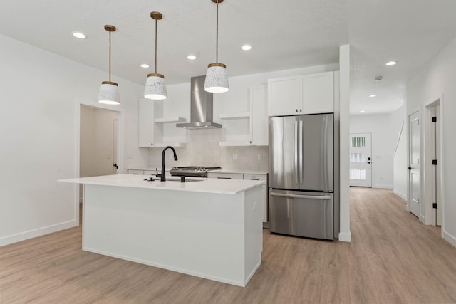 1215 S Radio Ln, Spokane Valley, WA 99212 - kitchen with freestanding refrigerator, wall chimney range hood, light wood-style floors, white cabinetry, and light countertops