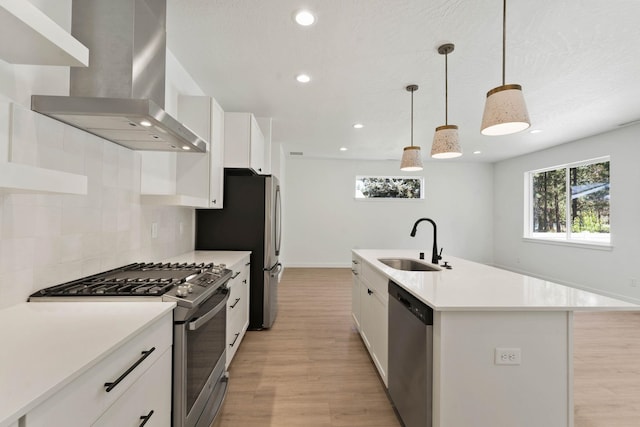 1215 S Radio Ln, Spokane Valley, WA 99212 - kitchen with wall chimney exhaust hood, appliances with stainless steel finishes, light wood-type flooring, backsplash, and white cabinets