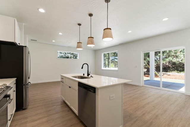 1215 S Radio Ln, Spokane Valley, WA 99212 - kitchen with appliances with stainless steel finishes, light wood finished floors, light countertops, recessed lighting, and white cabinetry