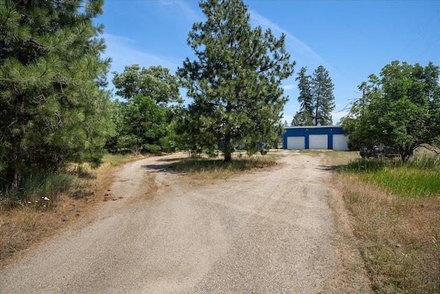 40010 N Newport Hwy, Elk, WA 99009 - view of front of home with dirt driveway, a garage, and an outbuilding