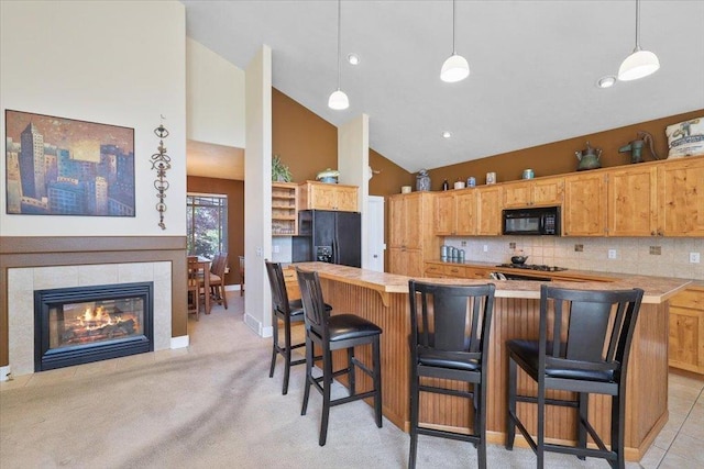 3405 W Kens Ct, Spokane, WA 99208 - kitchen featuring black appliances, high vaulted ceiling, a breakfast bar area, pendant lighting, and backsplash
