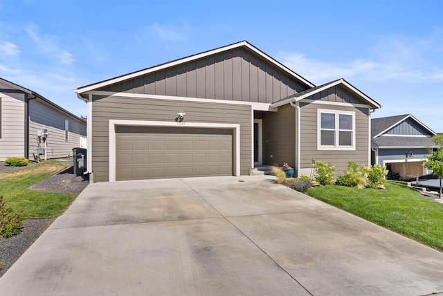 3228 N Mckinnon Rd, Spokane, WA 99217 - view of front facade with board and batten siding, a garage, driveway, and a front yard