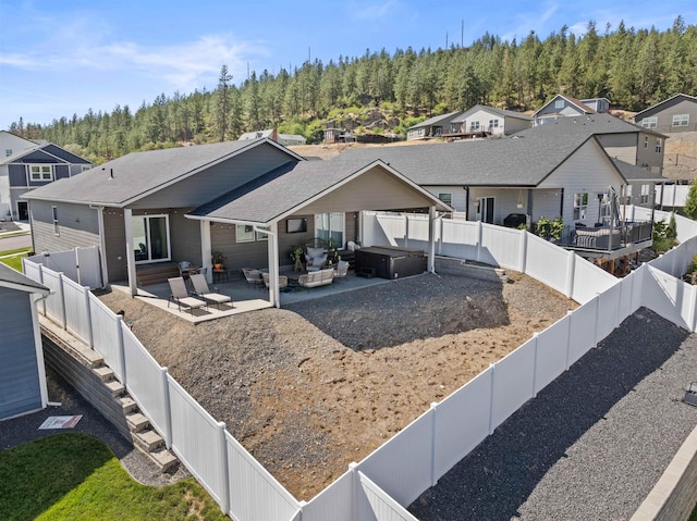 3228 N Mckinnon Rd, Spokane, WA 99217 - rear view of property featuring a hot tub, a patio area, a residential view, and a fenced backyard