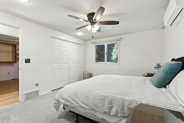 3832 S Cook St, Spokane, WA 99223 - carpeted bedroom with a wall mounted AC, a textured ceiling, a closet, and a ceiling fan