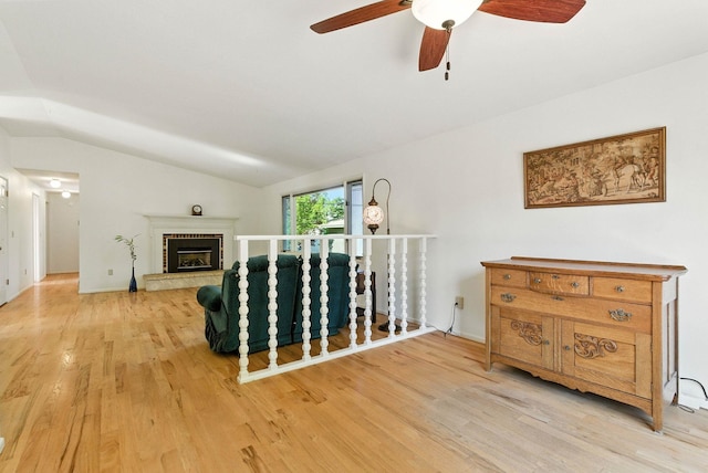 3832 S Cook St, Spokane, WA 99223 - living room featuring vaulted ceiling, ceiling fan, wood finished floors, and a brick fireplace