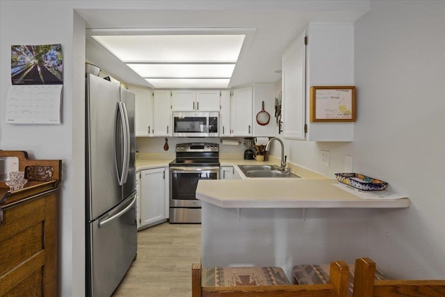 3714 S Alder Cir, Spokane, WA 99223 - kitchen featuring stainless steel appliances, a peninsula, light countertops, and light wood finished floors