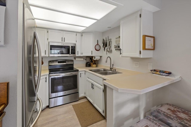 3714 S Alder Cir, Spokane, WA 99223 - kitchen with stainless steel appliances, light wood-style floors, white cabinetry, and a peninsula