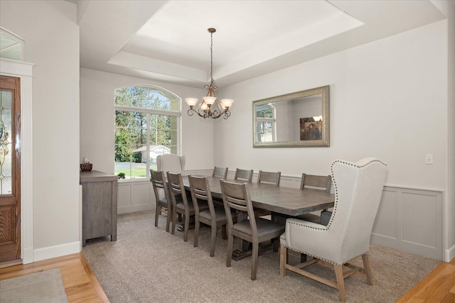 5614 N Thierman Rd, Spokane, WA 99217 - dining space with light wood-style flooring, a chandelier, a tray ceiling, and a wainscoted wall