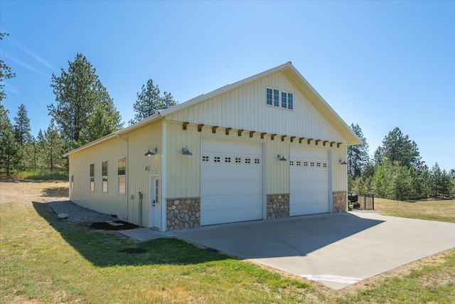 5614 N Thierman Rd, Spokane, WA 99217 - view of home's exterior with a garage, stone siding, an outdoor structure, and a yard