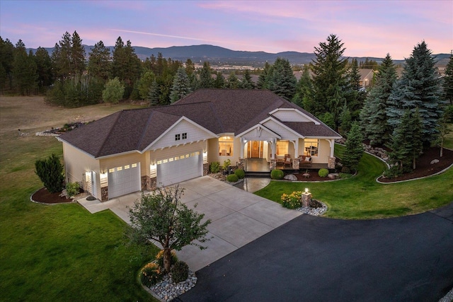 5614 N Thierman Rd, Spokane, WA 99217 - view of front of home with covered porch, an attached garage, a front yard, concrete driveway, and a mountain view