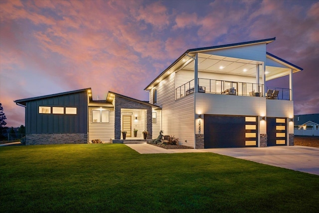 5257 S Falcon Point Ct, Spokane, WA 99224 - modern home with stone siding, a balcony, board and batten siding, an attached garage, and a front lawn