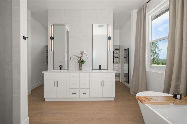 5257 S Falcon Point Ct, Spokane, WA 99224 - bathroom with double vanity, wood finished floors, and a freestanding tub