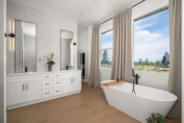 5257 S Falcon Point Ct, Spokane, WA 99224 - bathroom featuring wood finished floors, double vanity, and a freestanding bath