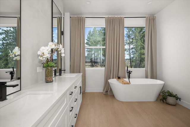 5257 S Falcon Point Ct, Spokane, WA 99224 - bathroom featuring wood finished floors, a freestanding bath, and double vanity