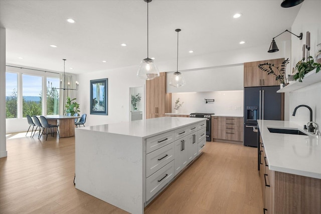 5257 S Falcon Point Ct, Spokane, WA 99224 - kitchen with stainless steel range oven, light wood-style flooring, recessed lighting, a spacious island, and black fridge