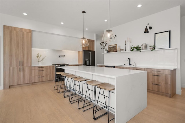 5257 S Falcon Point Ct, Spokane, WA 99224 - kitchen featuring modern cabinets, stainless steel electric range oven, black refrigerator with ice dispenser, a breakfast bar area, and light wood-style floors