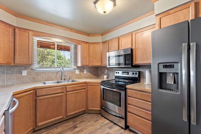 12911 E Desmet Ave, Spokane, WA 99216 - kitchen with appliances with stainless steel finishes, light countertops, backsplash, crown molding, and light wood-type flooring