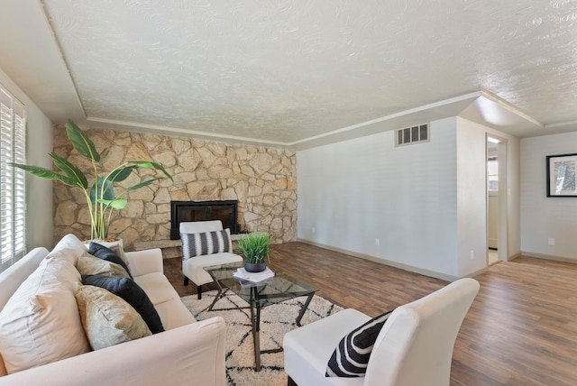 12911 E Desmet Ave, Spokane, WA 99216 - living room featuring a textured ceiling, wood finished floors, and a stone fireplace