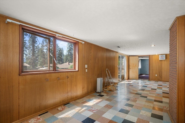 11322 E 18th Ave, Spokane, WA 99206 - unfurnished room with plenty of natural light, tile patterned floors, wood walls, and a textured ceiling