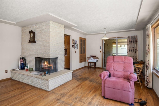 11322 E 18th Ave, Spokane, WA 99206 - living room with a textured ceiling, a fireplace, and hardwood / wood-style flooring