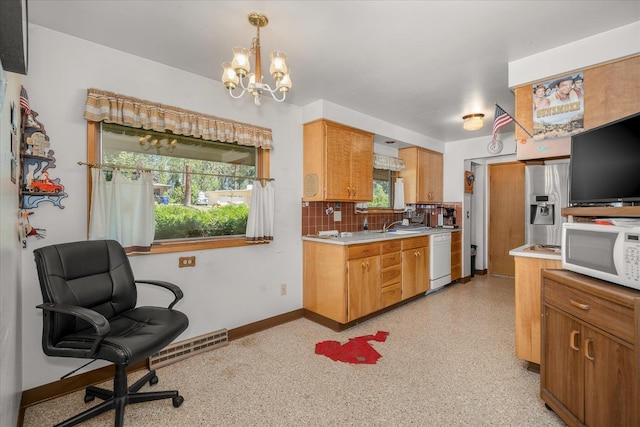 11322 E 18th Ave, Spokane, WA 99206 - kitchen with white appliances, light countertops, a chandelier, backsplash, and a desk