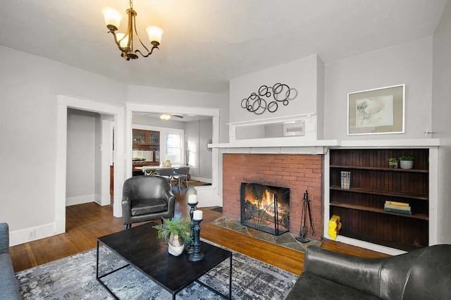 1518 W 6th Ave, Spokane, WA 99204 - living room featuring wood finished floors, a fireplace, and a chandelier