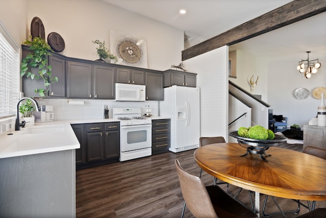 1611 W Tieton Ave, Spokane, WA 99208 - kitchen featuring white appliances, light countertops, dark wood-style flooring, backsplash, and a chandelier