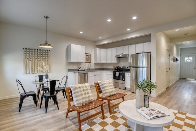 4907 E 6th Avenue 4909E 6Th Ave, Spokane Valley, WA 99212 - kitchen featuring appliances with stainless steel finishes, light wood-style flooring, under cabinet range hood, recessed lighting, and white cabinets