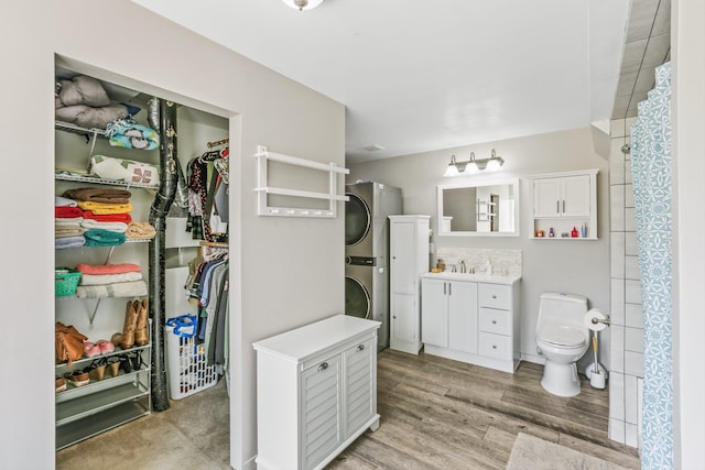 9906 E 17th Ln, Spokane Valley, WA 99206 - full bath with stacked washing machine and dryer, vanity, a spacious closet, wood finished floors, and a shower with curtain