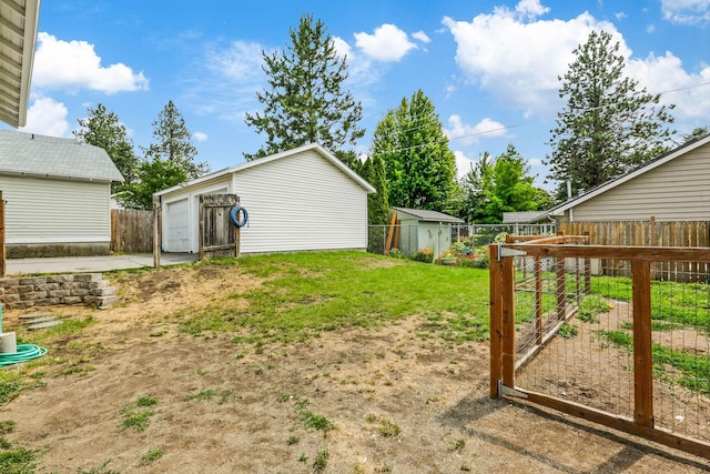 9906 E 17th Ln, Spokane Valley, WA 99206 - view of yard with an outdoor structure, a detached garage, and a vegetable garden