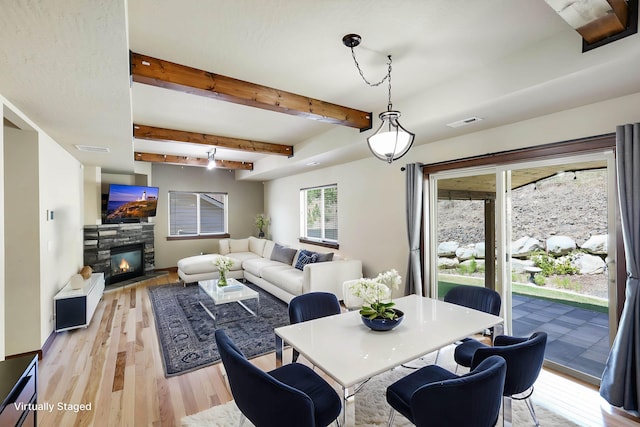 16319 E Whirlaway Ln, Veradale, WA 99037 - dining space featuring light wood finished floors, a stone fireplace, and beamed ceiling