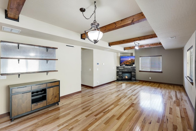 16319 E Whirlaway Ln, Veradale, WA 99037 - living area featuring healthy amount of natural light, light wood finished floors, a fireplace, and beamed ceiling