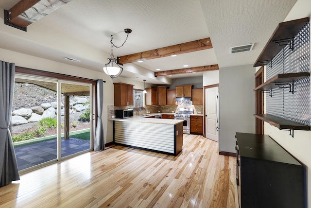 16319 E Whirlaway Ln, Veradale, WA 99037 - kitchen with appliances with stainless steel finishes, a peninsula, light countertops, tasteful backsplash, and light wood-type flooring