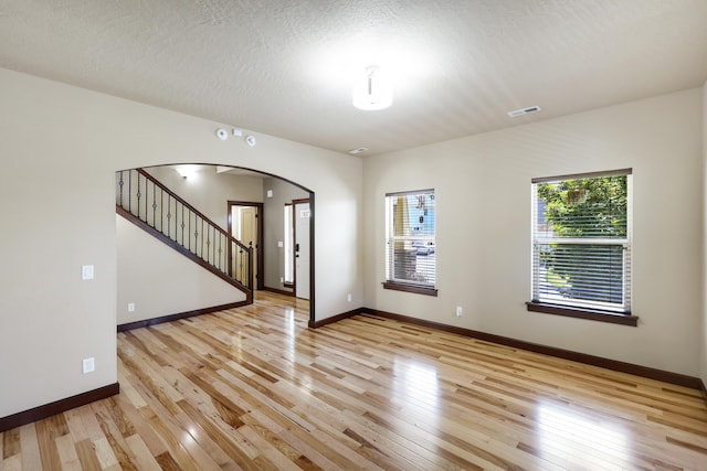 16319 E Whirlaway Ln, Veradale, WA 99037 - unfurnished room featuring arched walkways, light wood finished floors, and stairs