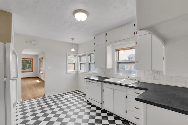 1728 W Spofford Ave, Spokane, WA 99205 - kitchen with white appliances, arched walkways, dark countertops, a textured ceiling, and decorative backsplash