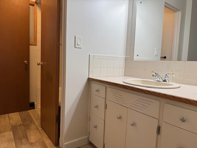 6412 N Fotheringham St, Spokane, WA 99208 - bathroom featuring vanity, wood finished floors, and decorative backsplash