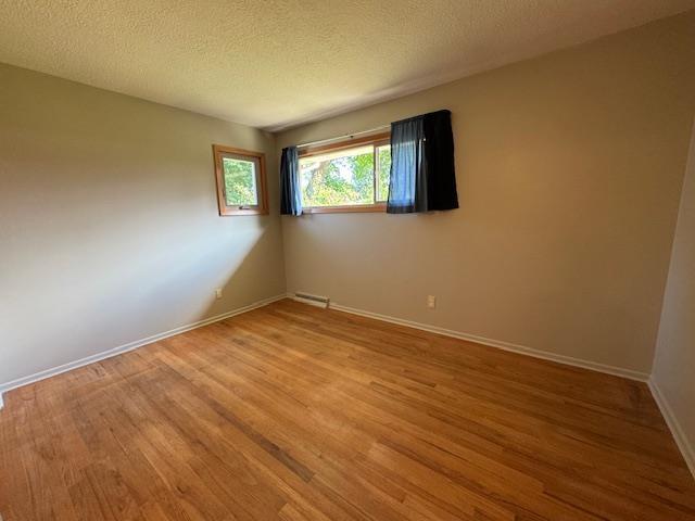 6412 N Fotheringham St, Spokane, WA 99208 - empty room featuring wood finished floors and a textured ceiling