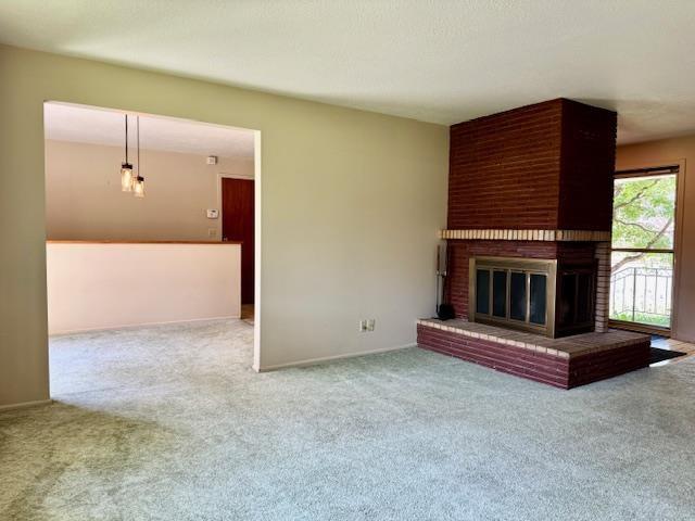6412 N Fotheringham St, Spokane, WA 99208 - unfurnished living room featuring carpet and a brick fireplace