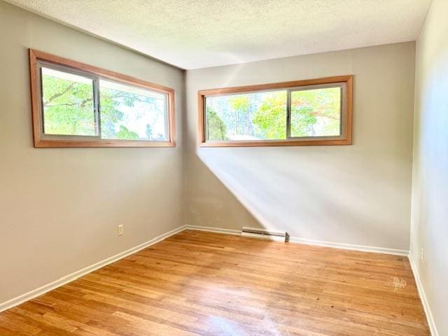 6412 N Fotheringham St, Spokane, WA 99208 - unfurnished room with wood finished floors, a baseboard radiator, and a textured ceiling
