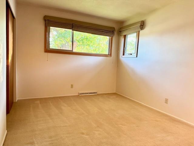6412 N Fotheringham St, Spokane, WA 99208 - spare room with light carpet and a baseboard radiator
