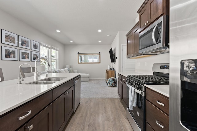 1225 E Paske Rd, Colbert, WA 99005 - kitchen with stainless steel appliances, open floor plan, light countertops, light wood finished floors, and dark brown cabinetry